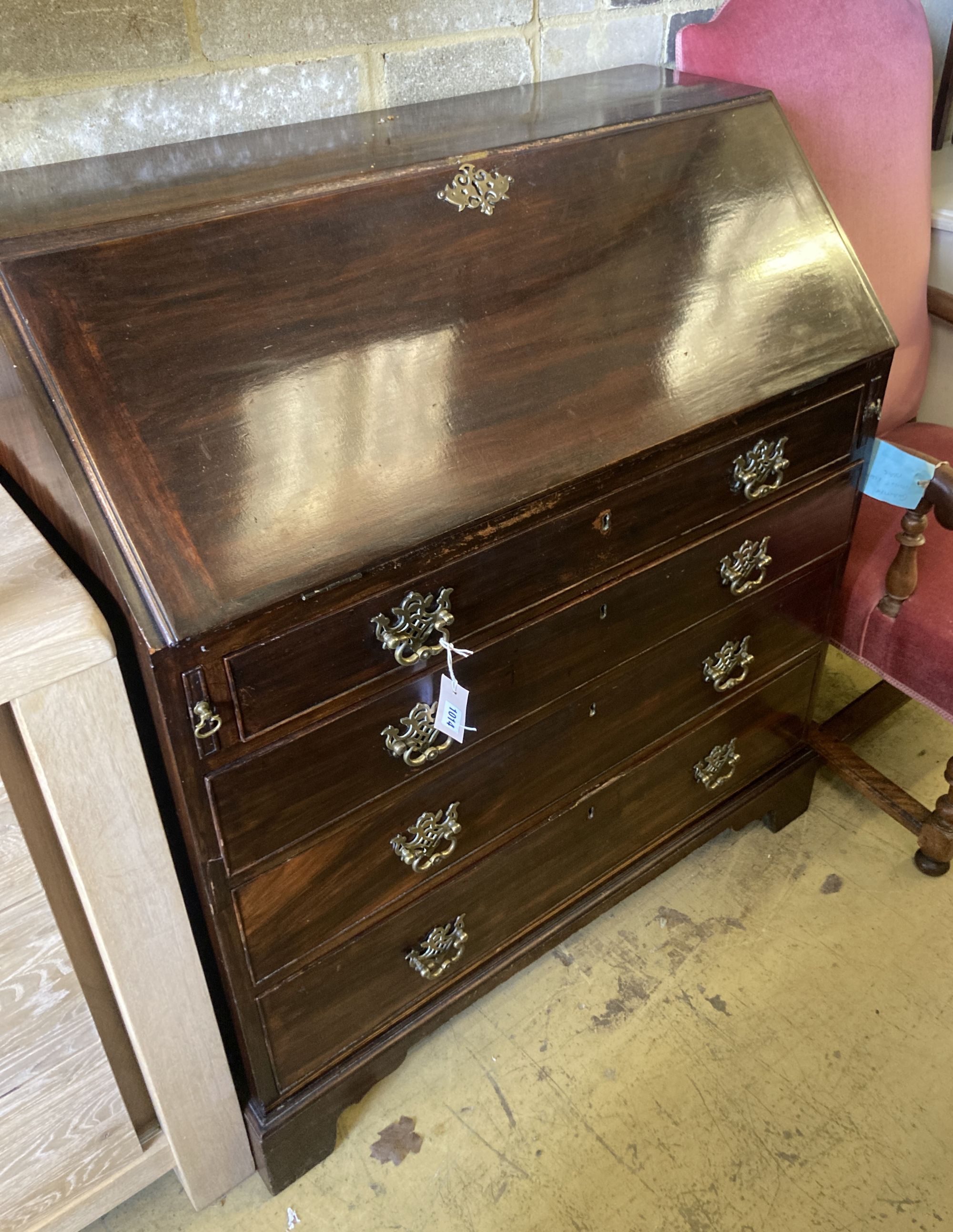 A George III mahogany bureau, the fall enclosing drawers, pigeon holes and secret compartments over four long drawers, width 97cm, dept